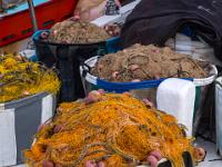 Säcke voller Fischernetze am Schiffsbug